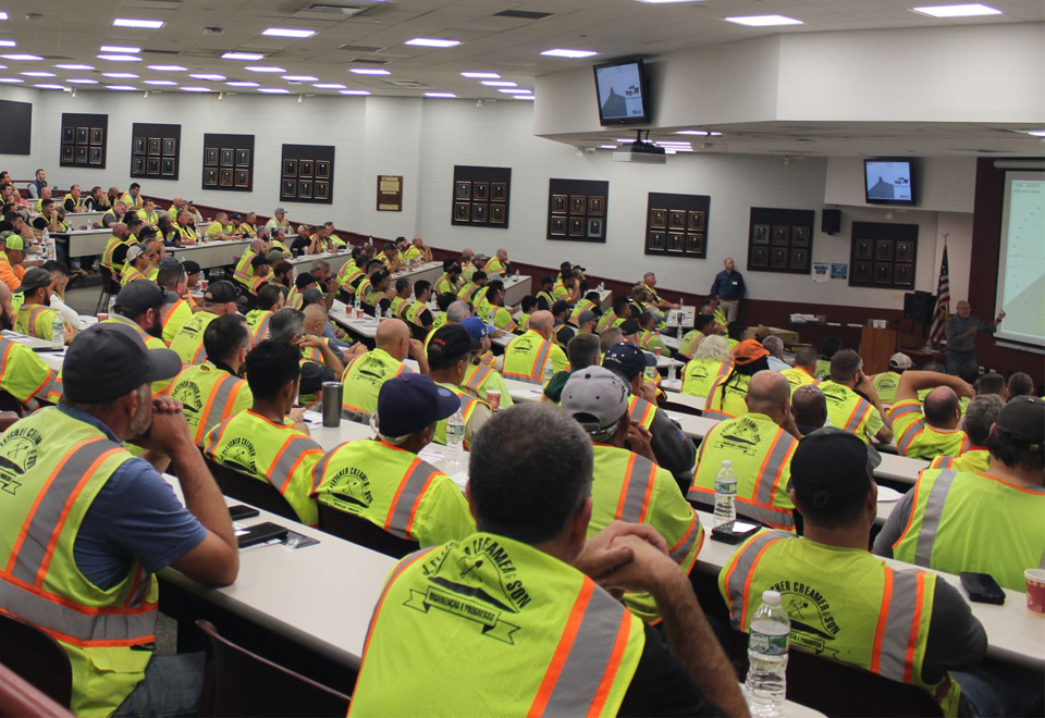 A coworker as Davis-Ulmer Fire Protection points to a system control while speaking to a coworker.