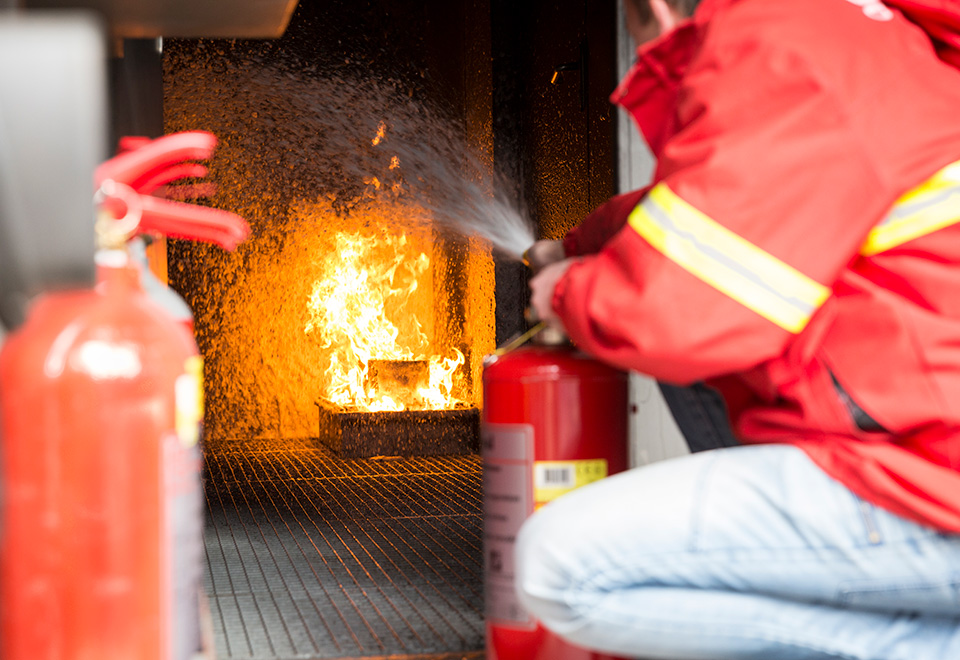 A coworker tests fire extinguishers.