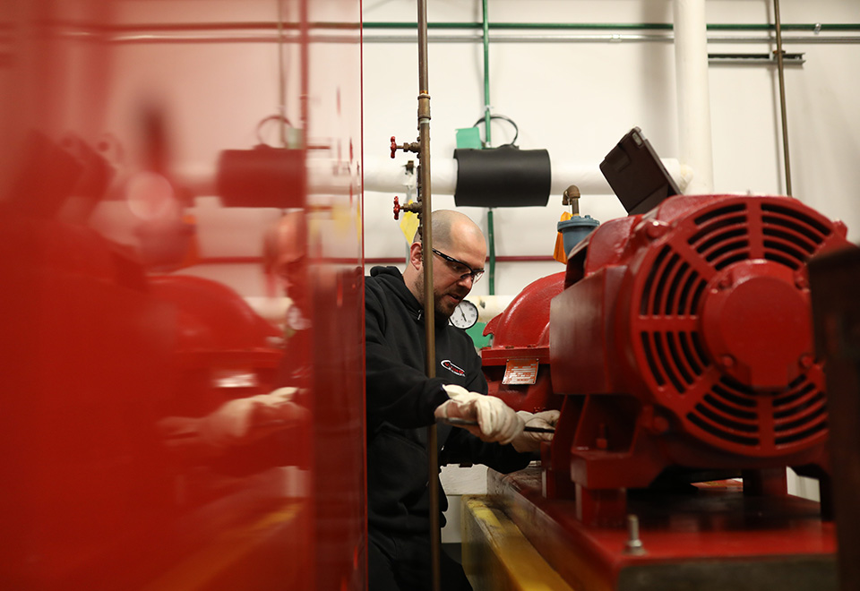 A technician adjusts a machine on a job site.